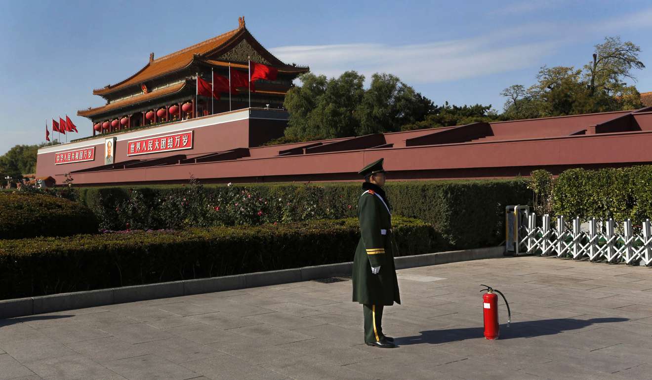 A Chinese paramilitary policeman stands guard with a fire extinguisher in front of Tiananmen Gate in Beijing. Photo: AP