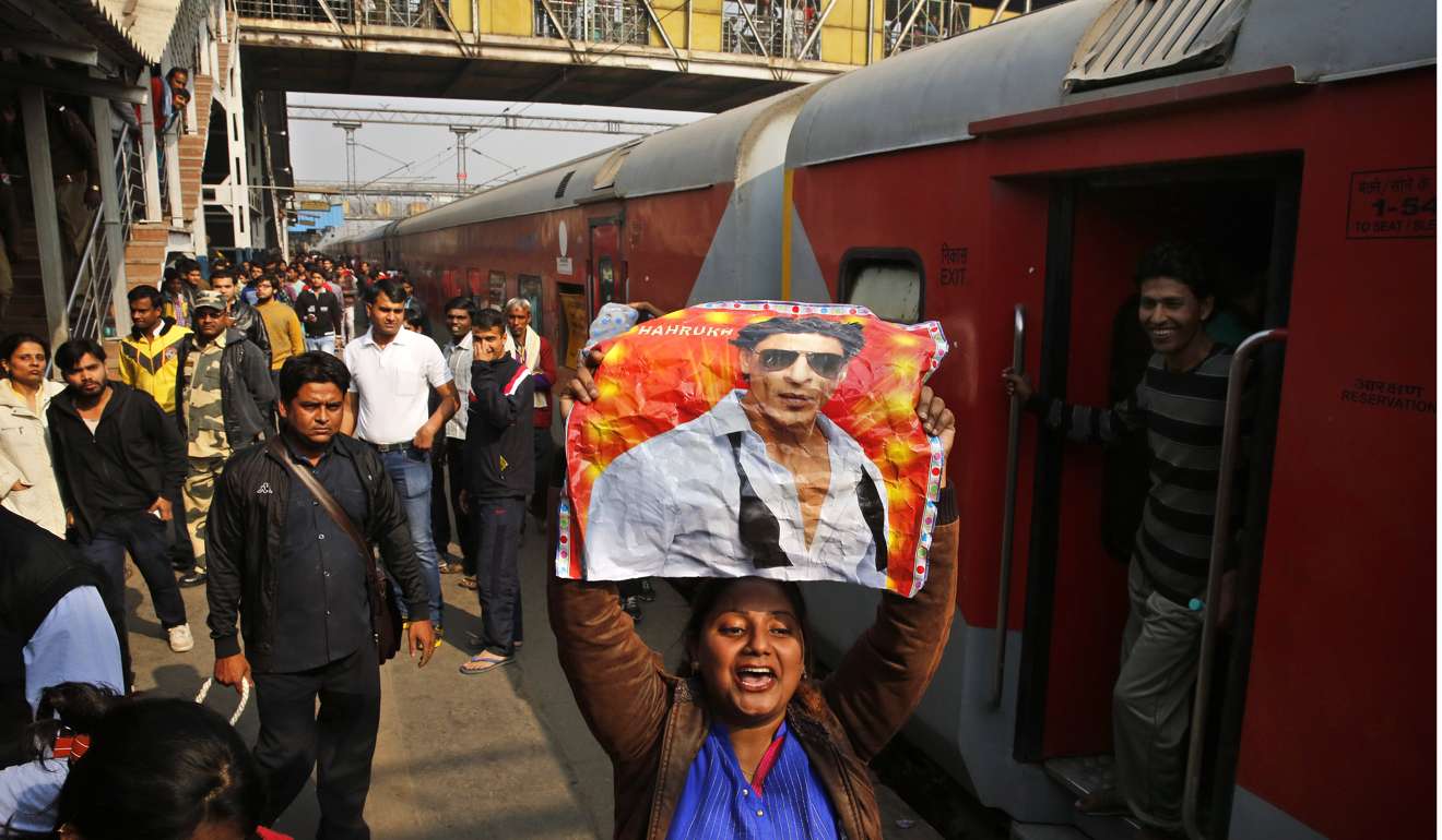 An Indian fan holds a poster of Bollywood actor Shah Rukh Khan at the platform of the Hazrat Nizamuddin Railway Station as he was expected to arrive to promote his upcoming movie Raees in New Delhi, India. Photo: EPA