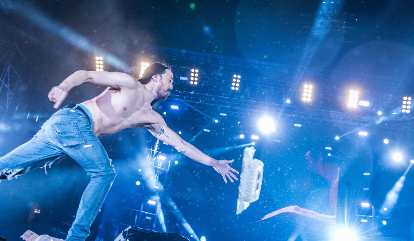 DJ Steve Aoki throws cake at the audience.