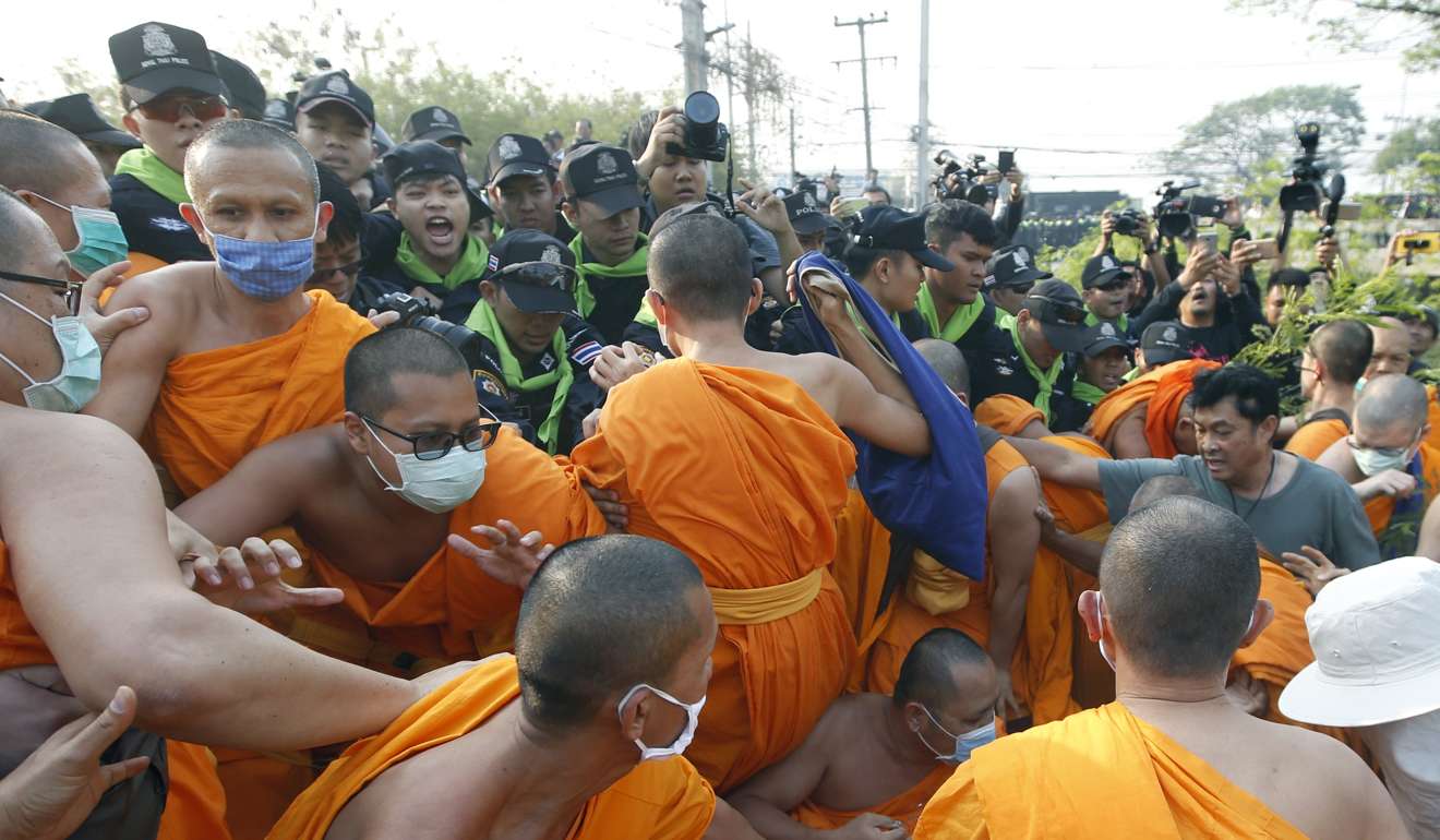 Buddhist monks of Dhammakaya Temple and their supporters scuffle with police officers outside the temple. Photo: EPA