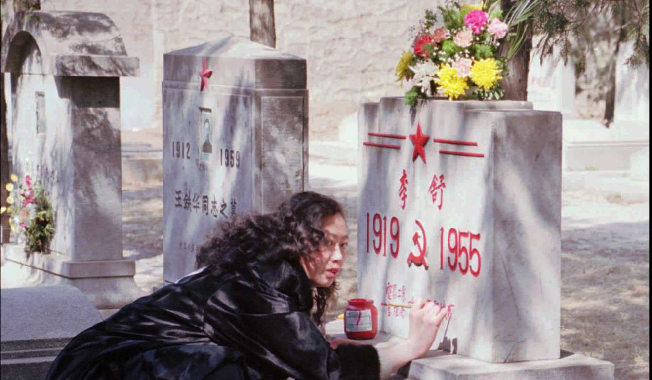 A Chinese lady repaints lettering on the grave of a relative at Beijing's Babaoshan cemetary. Photo: AP