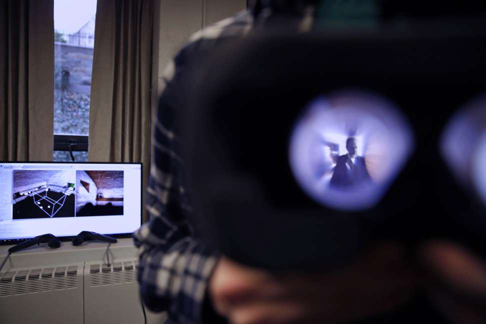 Boston College student Michael Quinn holds up virtual reality goggles while working to bring literature to life. Photo: AP
