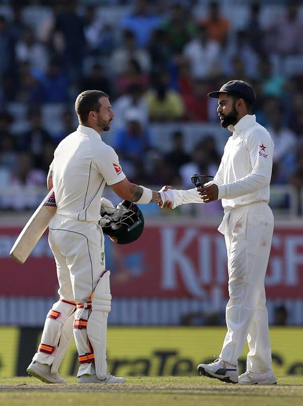 Kohli shakes hands with Australia’s Matthew Wade at the end of the third test. Photo: AP