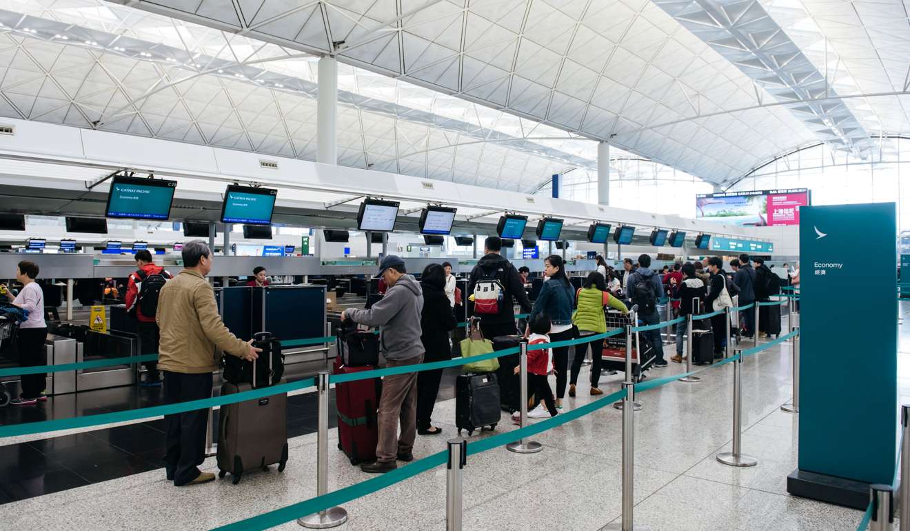 Travellers queue up at Cathay Pacific’s check-in counters at Hong Kong International Airport in Hong Kong. Photo: Bloomberg