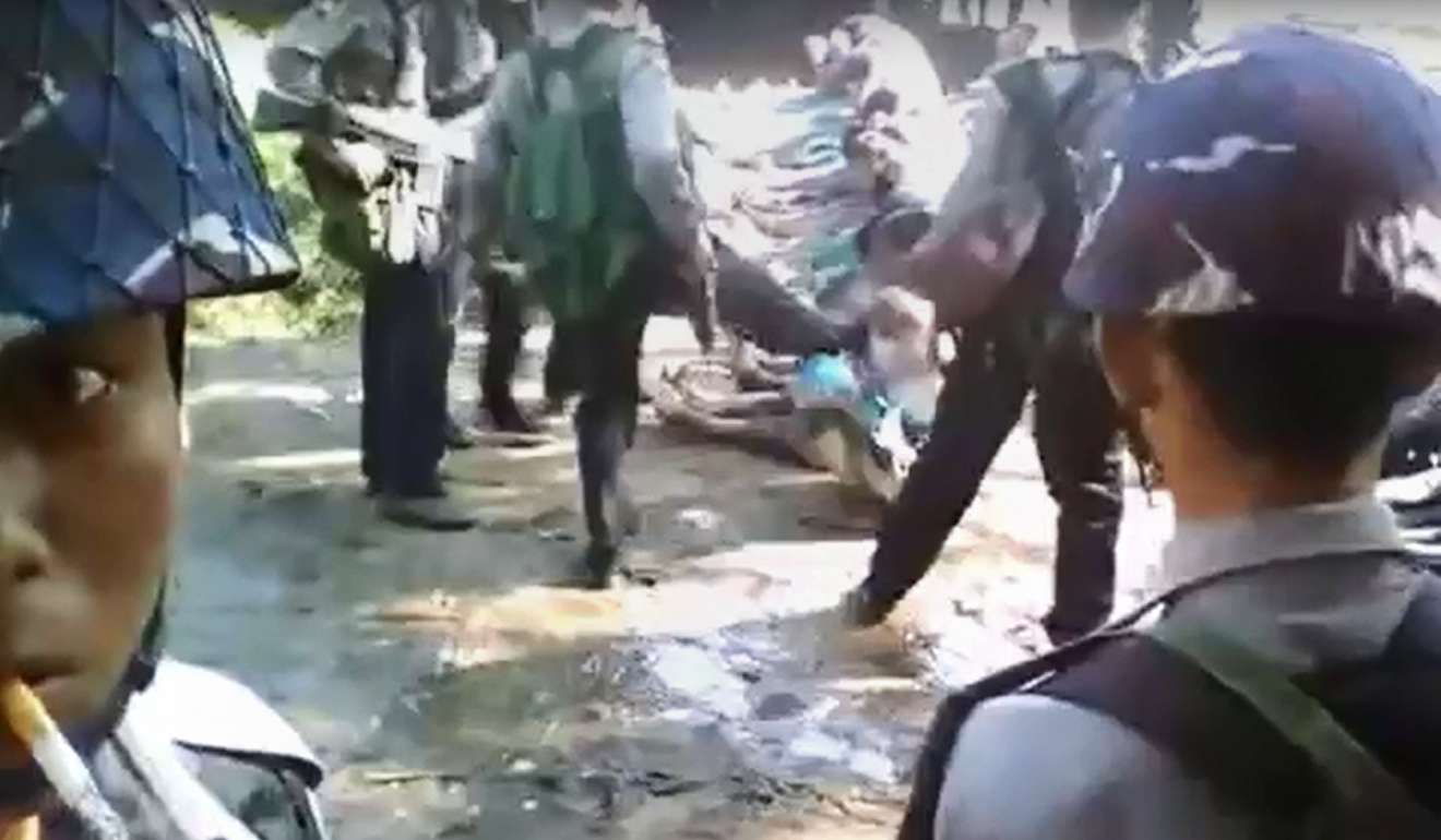 A policeman kicks a Rohingya villager seated on the ground with others, in the village of Kotankauk during a clearance operation in 2016. File photo: YouTube