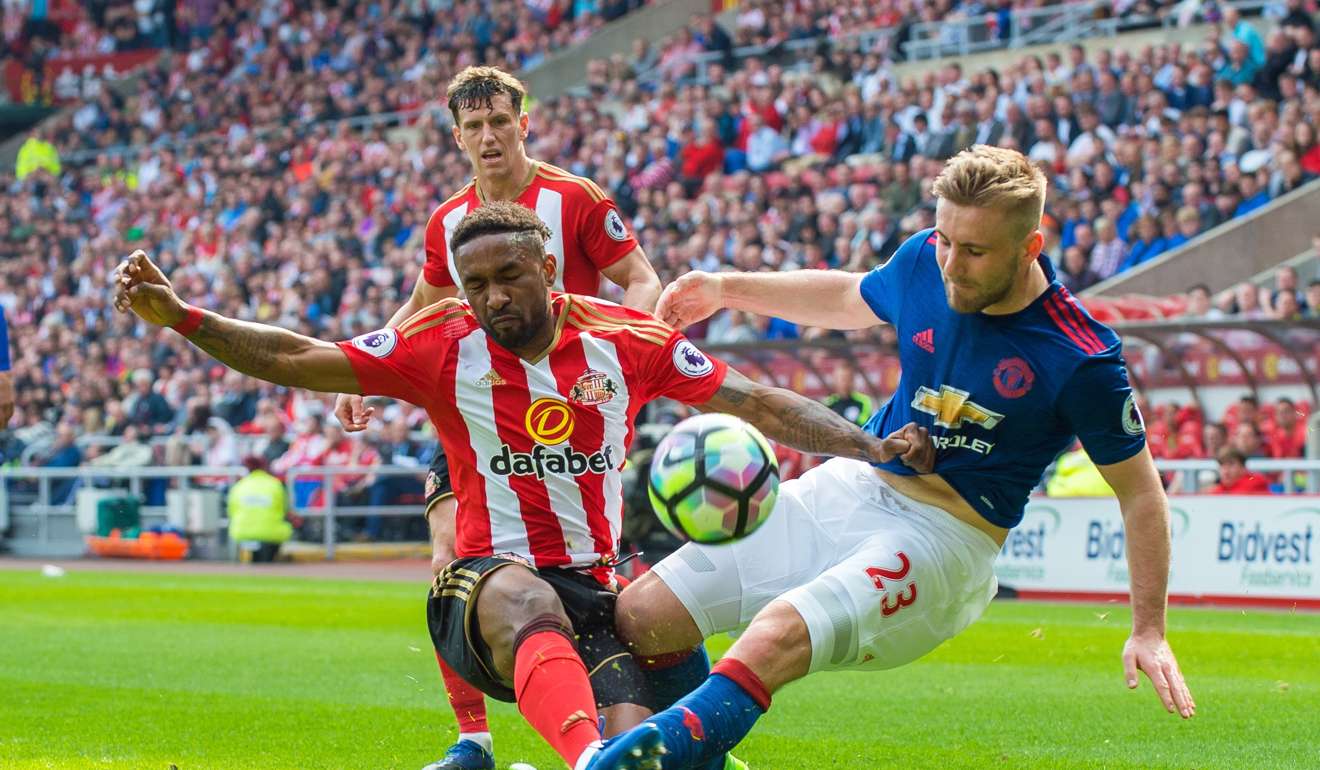 Luke Shaw goes in for a tackle with Jermain Defoe. Photo: EPA