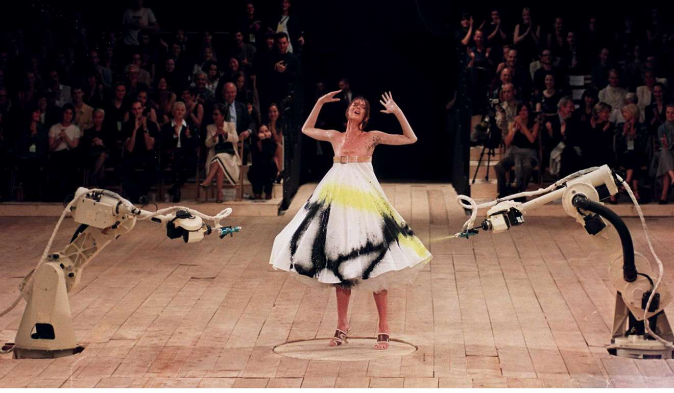 Robots spray-paint a model's dress during Alexander McQueen’s spring-summer 1999 collection at London Fashion Week
