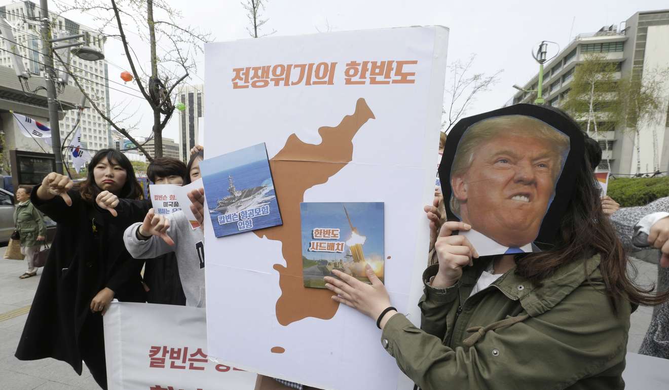 Protesters hold a cutout of US President Donald Trump and images of the USS Carl Vinson aircraft carrier and US missile defence system THAAD during a rally against US deployment of the aircraft carrier to the Korean Peninsula, near the US embassy in Seoul, South Korea. Photo: AP