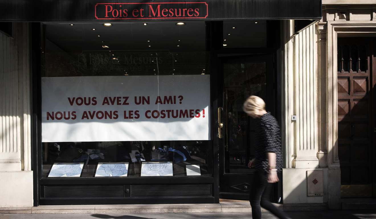 A woman walks past sign in a shop front in Paris reading “you have a friend? we have the suits”, a play on the scandal surrounding presidential candidate Francois Fillon and his designer wardrobe, paid for by a rich donor. Photo: AFP
