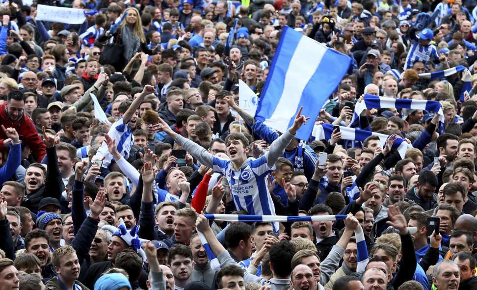 Brighton and Hove Albion fans celebrate their team’s promotion on the pitch. Photo: AP