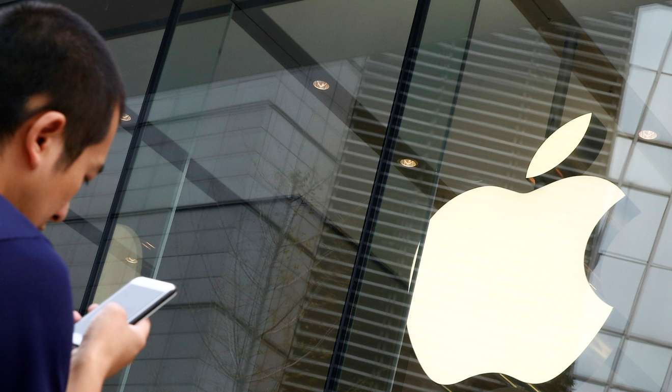 A man uses an Apple smartphone outside an Apple store in Beijing. Photo: Reuters