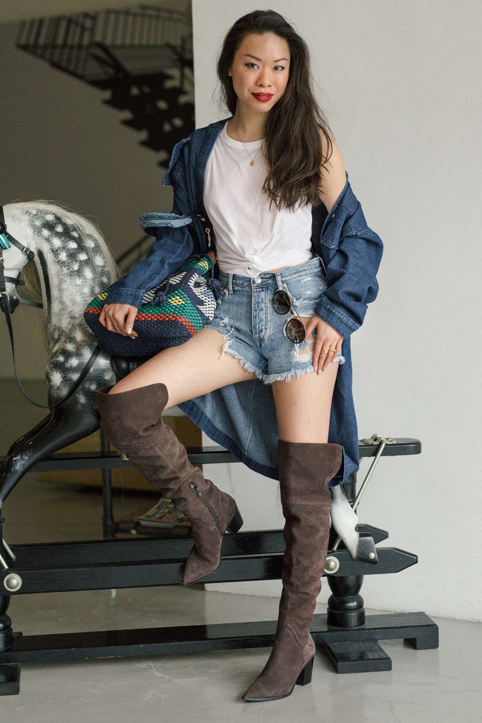 At work, Ling wears a denim shirt from ST Studio, white top from Club Monaco, shorts from American Eagle Outfitters, cowboy thigh-high boots from Aldo, sunglasses by Gucci, and necklace from David Yurman. Photo shot at The Piers Studios. Photo: Fan Wu
