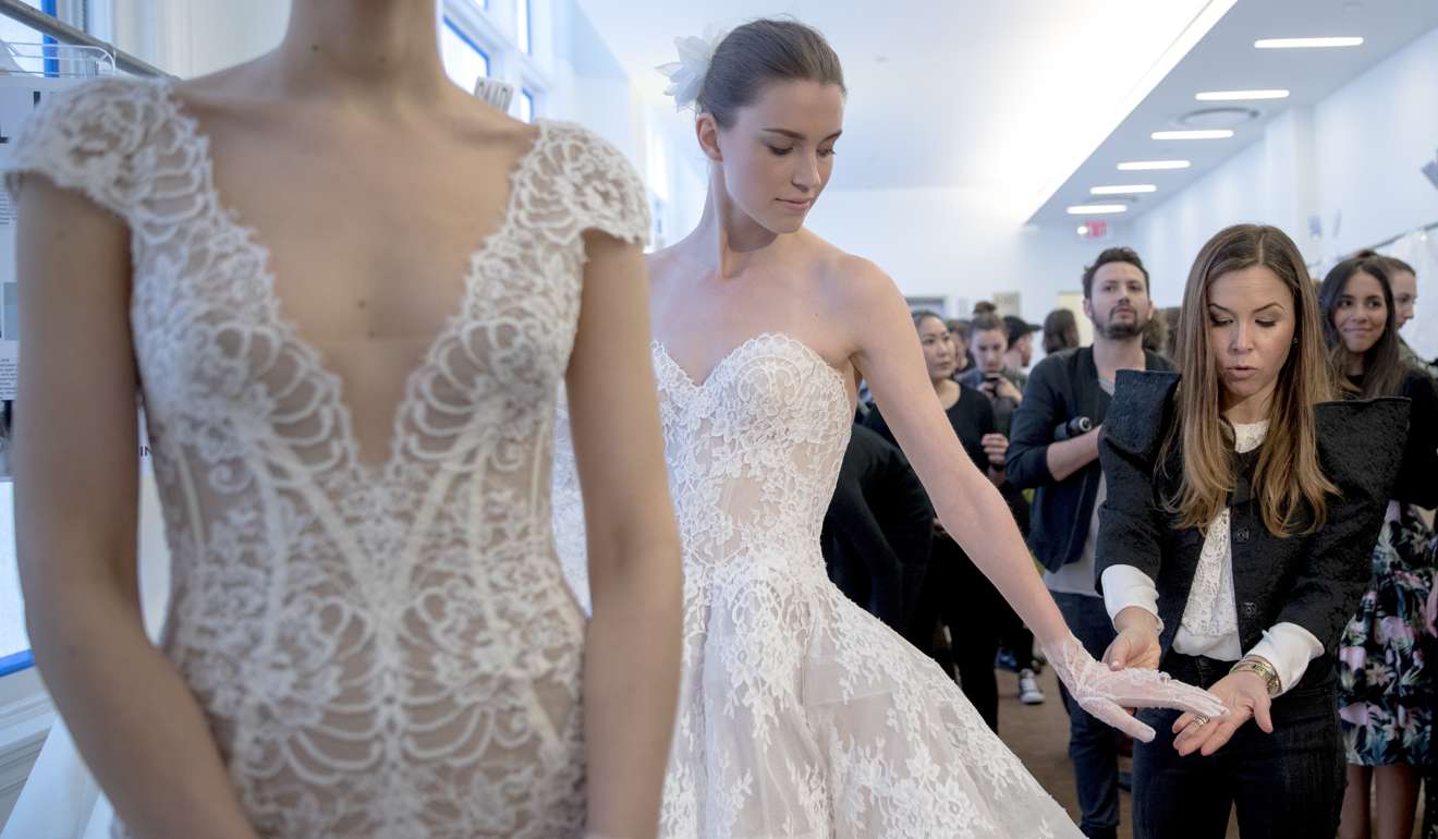Monique Lhuillier, right, speaks to a reporter ahead of her collection presentation during Bridal Fashion Week in New York. Photo: AP