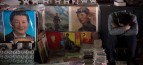 A vendor takes a nap next to posters showing Mao Zedong (centre) and Xi Jinping (left) at a market in Beijing. Photo: AFP