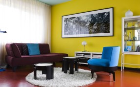The living room features lemon yellow walls in stark contrast with a duck-egg blue ceiling and vermillion floor, not to mention the electric blue chairs and plum divan sofa. Photography: Helenio Barbetta The living room features lemon yellow walls in stark contrast with a duck-egg blue ceiling and vermillion floor, not to mention the electric blue chairs and plum divan sofa. Photography: Helenio Barbetta
