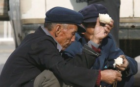Migrant workers eat their lunch on a sidewalk in Beijing. The National Bureau of Statistics said there were more than 277 million migrant workers in China in 2015. Photo: EPA