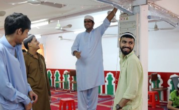 Muslims share a light moment as they decorate the Idara Minhaj-ul-Quran mosque in Kwai Chung in preparation for celebrations of the end of Ramadan. Photo: Bruce Yan