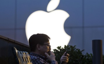 A man uses his mobile phone near a Apple store. Photo: AP Photo