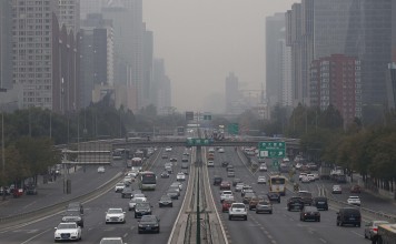 Smog hovers over a main road in Beijing last week. Neighbouring Hebei province has ordered drugmakers to stop production until the smog eases. Photo: EPA