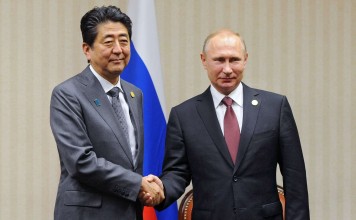 Russian President Vladimir Putin and Japanese Prime Minister Shinzo Abe shaking hands during a meeting on the sidelines of the Asia-Pacific Economic Cooperation Leaders' Meeting in Lima. Photo: AFP