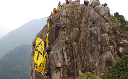 Firemen remove the banner off Lion Rock at 1pm. Photo: Robert Ng Firemen remove the banner off Lion Rock at 1pm. Photo: Robert Ng