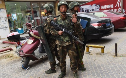 Paramilitary police officers on guard by a shopping centre in Hotan in Xinjiang. Photo: AFP Paramilitary police officers on guard by a shopping centre in Hotan in Xinjiang. Photo: AFP