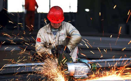 A worker polishes metal at steelworks factory in Rizhao, in eastern China's Shandong province. Photo: AFP
