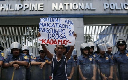 A Filipino human rights advocate holds a placard as he joins a demonstration in front of the Philippine National Police (PNP) headquarters, protesting the alarming number of deaths related to government's war against illegal drugs, in Quezon city, east of Manila. Photo: EPA
