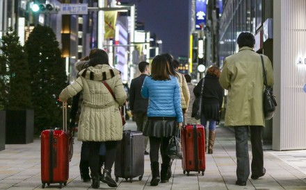 Chinese tourists carry suitcases packed with purchases after bulk buying, or ‘Bakugai’ in central Tokyo. Chinese tourists' shopping makes a large contribution to the Japanese economy. Photo: EPA