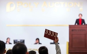 A bidder offers a price at Poly Auction's spring sale in Hong Kong. The Zhou Village, an oil painting by Wu Guanzhong, sold for HK$236 million at Poly Auction's spring sale on Monday. Photo: Xinhua
