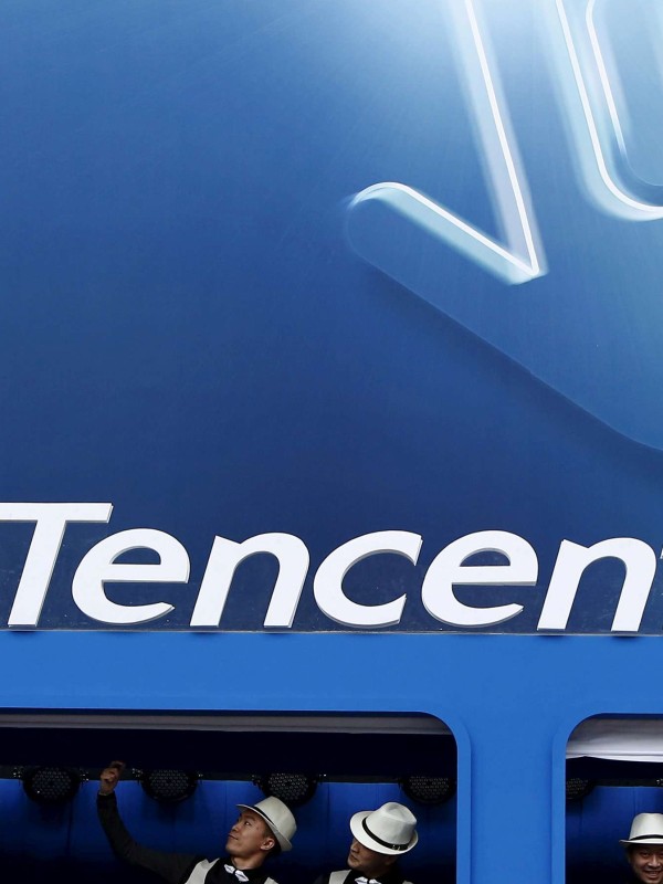 Dancers perform underneath the logo of Tencent at the Global Mobile Internet Conference in Beijing. Photo: