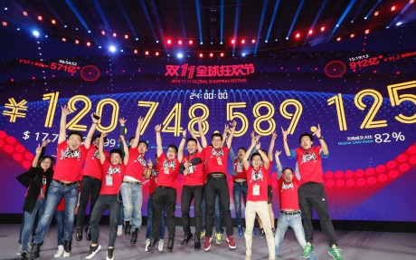 Staff members celebrate in front of a giant screen displaying total gross merchandise volume (GMV) of Alibaba's online marketplace Tmall for the Singles' Day shopping spree in Shenzhen. Photo: Xinhua