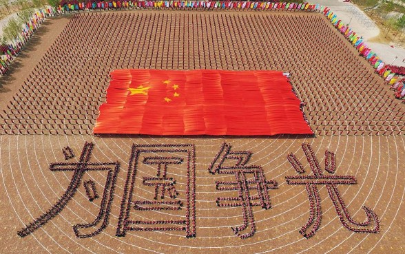 Some 26,000 students of the Shaolin Temple Tagou Martial Arts School in Dengfeng, Henan province, form the Chinese flag and slogan which translates as “Win glory for the nation” for a huge martial arts performance during the opening ceremony of the school’s spring training programme. Photo: AFP Some 26,000 students of the Shaolin Temple Tagou Martial Arts School in Dengfeng, Henan province, form the Chinese flag and slogan which translates as “Win glory for the nation” for a huge martial arts performance during the opening ceremony of the school’s spring training programme. Photo: AFP