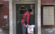 A courier with Jingdong, also known as JD.com, rings the bell of an apartment where he is making a delivery, in Beijing. Photo: Reuters