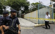 North Korean official walks towards armed police guarding outside the North Korean embassy in Kuala Lumpur. Photo: EPA