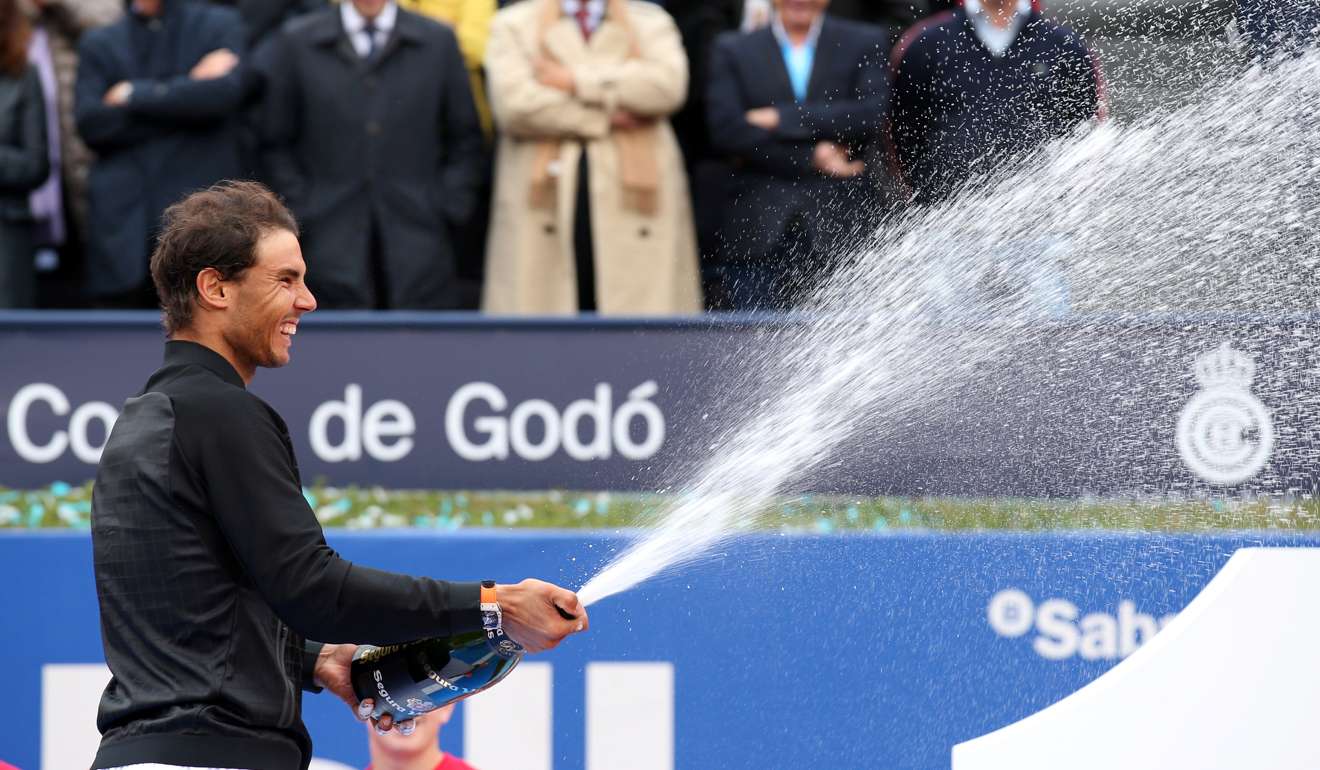 Rafael Nadal showers the podium with celebratory champagne. Photo: Reuters