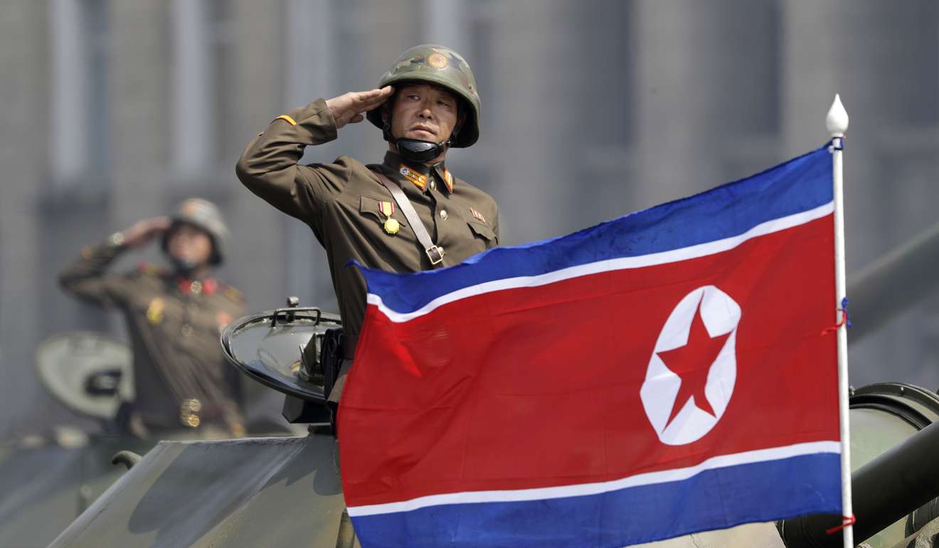 A North Korean national flag flutters as soldiers in tanks salute leader Kim Jong-un a military parade in Pyongyang. Photo: AP