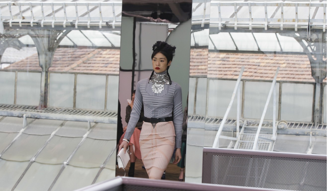 A model reflected in a mirror wears a creation part of the women's Prada Cruise mid season collection, first ever runway show. Photo: AP