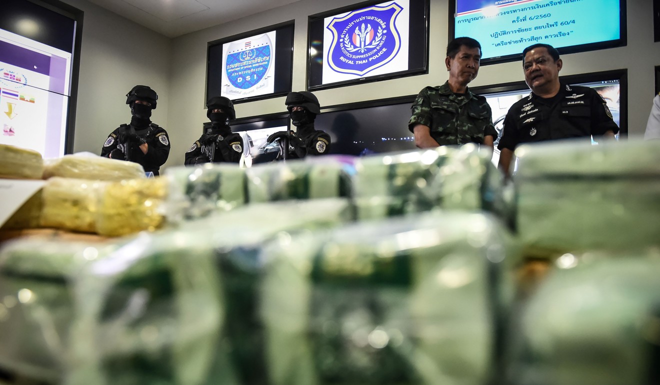 Thai law enforcement officers standing behind packages of Ice and ketamine during a press conference at the Office of the Narcotics Control Board in Bangkok. Photo: AFP