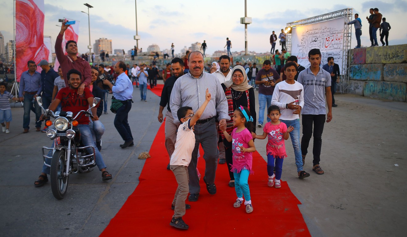 Palestinians walk on the red carpet during a festival showcasing films focusing on human rights in Gaza City on May 12, 2017. Photo: AFP