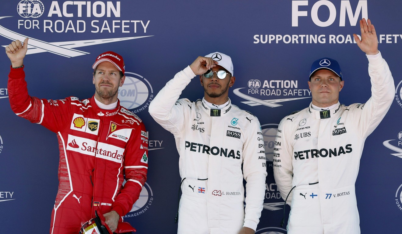 Lewis Hamilton (centre), Sebastian Vettel (left) and Valtteri Bottas celebrate their pole position, second and third best times, respectively. Photo: EPA