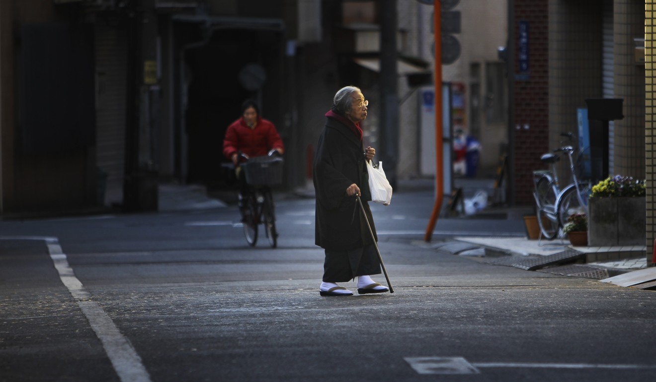 A kimono-clad elderly woman walks across a street in Tokyo. Photo: AP
