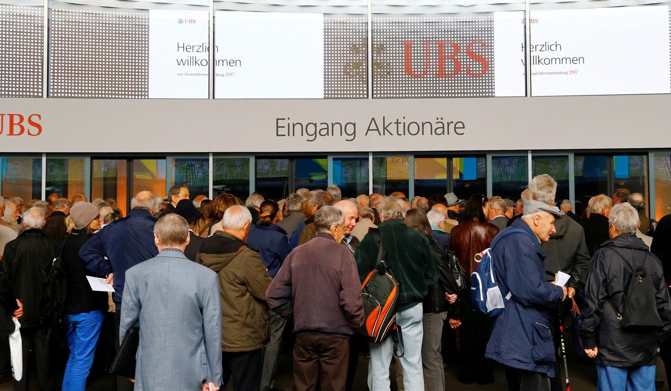 Participants arrive ahead of the annual shareholder meeting of Swiss bank UBS in Basel, Switzerland. Singapore GIC sovereign wealth fund is selling part of its stake in the banking giant. Photo: Reuters