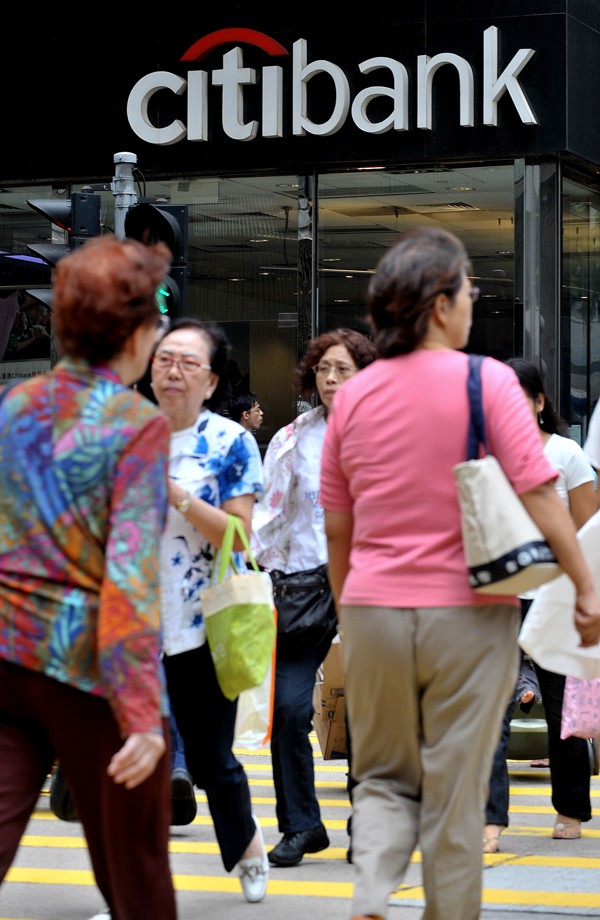People cross the street next to a Citibank branch in Hong Kong. Photo: AFP