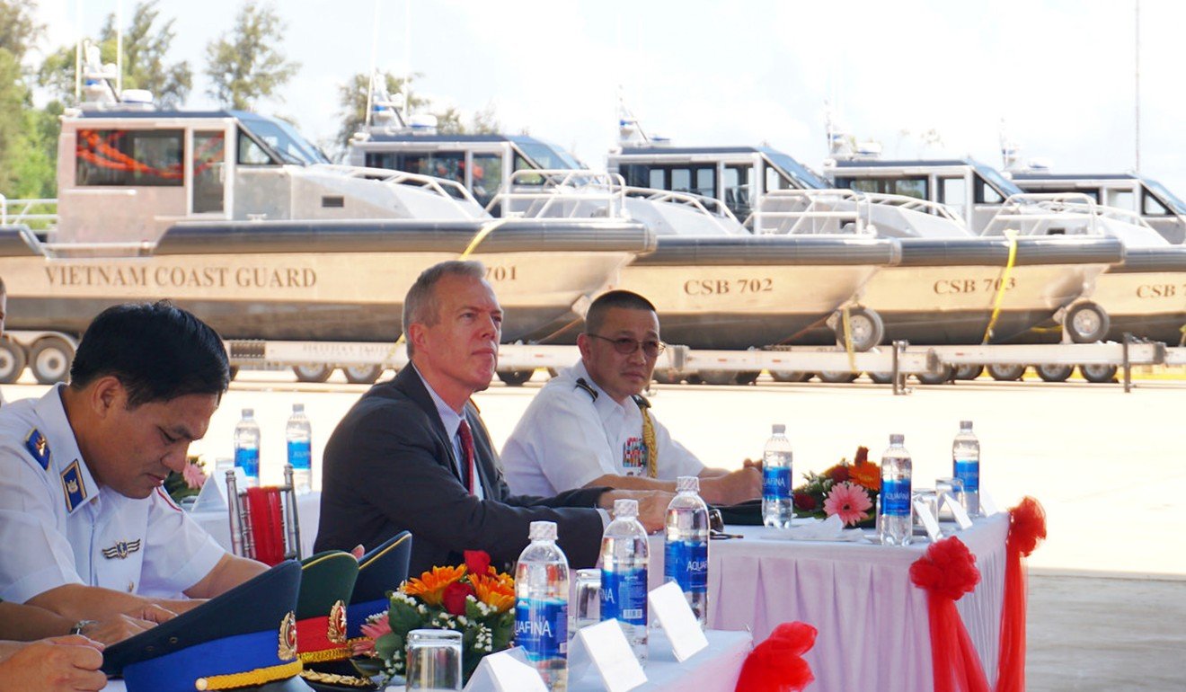 US Ambassador Ted Osius sits with Vietnam coastguard members during a delivery ceremony of patrol boats. Photo: AP