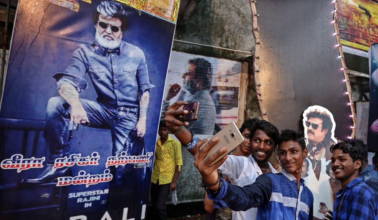 Indian fans of superstar Rajinikanth take selfies with his posters as they celebrate the release of ‘Kabali’. Photo: EPA