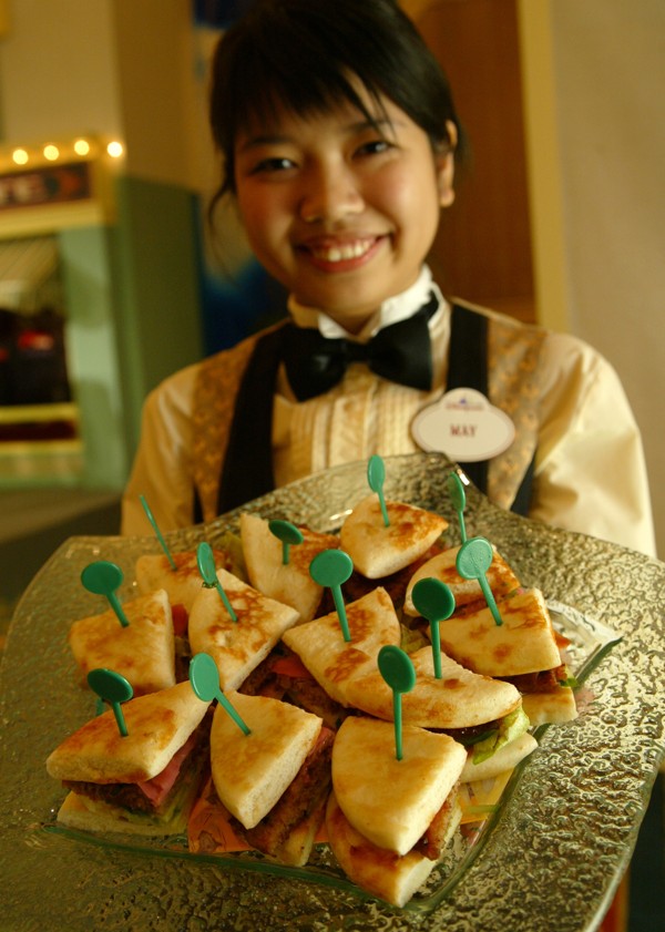 Waitress May serves a “char siew” pork burger to guests at Hong Kong Disney Hotel. Photo: SCMP