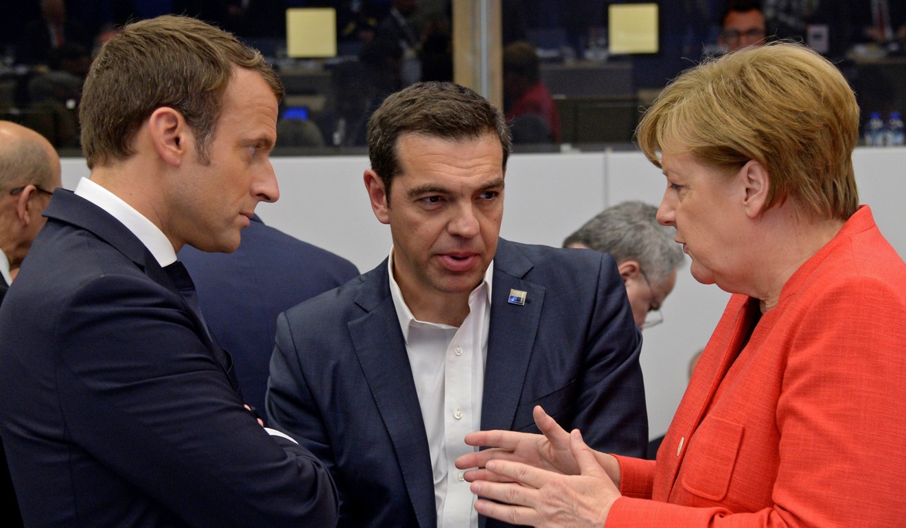 German Chancellor Angela Merkel (R) gestures as she speaks with Greek Prime Minister Alexis Tsipras (C) and French President Emmanuel Macron (L) during a working dinner meeting at the NATO summit in Brussels. Photo: EPA