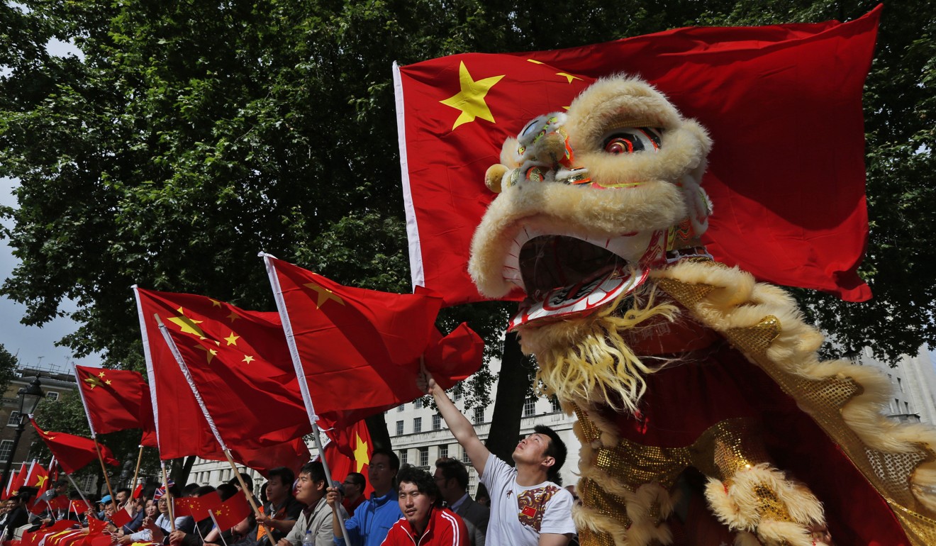 Chinese students wave their national flags as they gather in support of Chinese Premier Li Keqiang during his visit at Downing Street in London in June 2014. Photo: AP