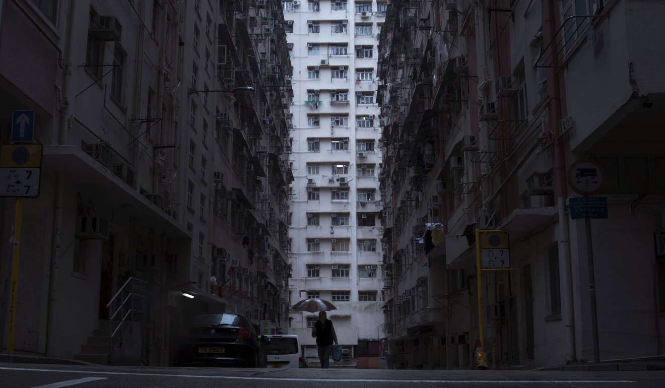 A man walks in front of a residential building in Hong Kong that houses so-called ‘coffin homes’. In wealthy Hong Kong, there’s a dark side to a housing boom, with hundreds of thousands of people forced to live in partitioned shoebox apartments. Photo: AP